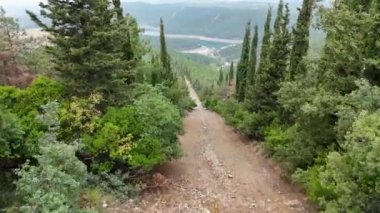 4k Video. İnsansız hava aracı toprak yolda küçük gölet manzarasına uçuyor..