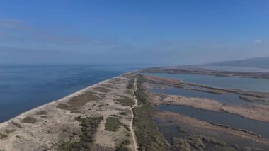 Kıyı Kucaklaşması: Bir İHA 'nın İnce Engelli Bariyerin Üzerinde Genişleyerek Geniş Bataklıklardan Serene Gökyüzü Okyanusunu Bölmesi ve Uzaktan Yükseklere Karşı Verimliliği.