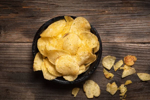 stock image Crispy potato chips in a bowl on a wooden background