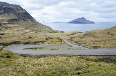 Norradalur 'a giden kıvrımlı bir yol, Faroe Adaları' nda küçük bir köy, Kuzey Avrupa