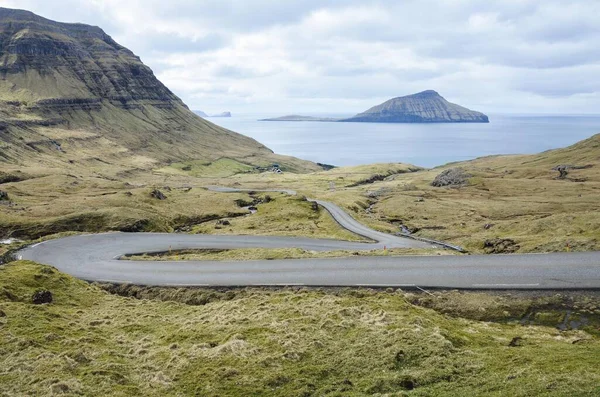 Norradalur 'a giden kıvrımlı bir yol, Faroe Adaları' nda küçük bir köy, Kuzey Avrupa