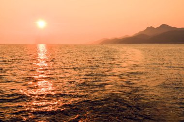 Hırvatistan, Avrupa 'daki Mljet adasının arkasında güzel bir günbatımı. Mljet adası bir yelkenliden.
