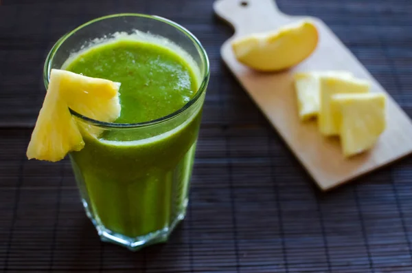 Koyu arkaplanda ananas, elma ve tohumlu taze çiğ ıspanak püresi.
