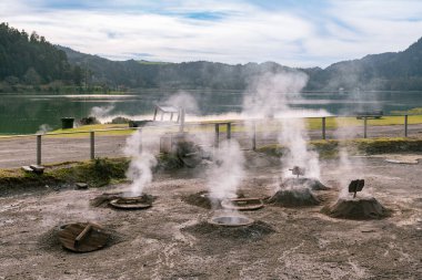 Sao Miguel adasındaki Furnas Gölü kıyısında yemek pişirmek için kullanılan buharlı çukurlar. Azores takımadaları, Portekiz.