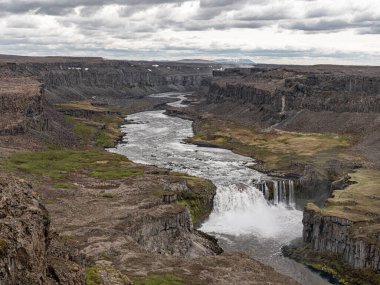 Şelale manzaralı Hafragilsfoss ve etrafındaki Jokulsargljufur kanyonu kuzey İzlanda 'daki Jokulsa a Fjollum nehrinin doğu kıyısından görüldü.