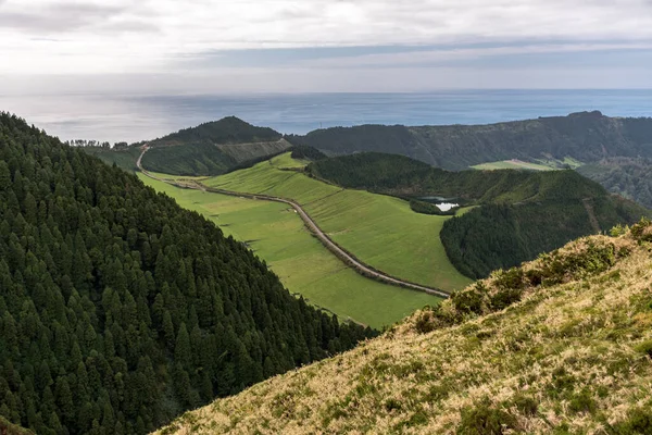 Sao Miguel adasındaki küçük krater gölü Lagoa Rasa ile Sete Cidades Caldera kenarının panoramik görüntüsü. Azores takımadaları, Portekiz.