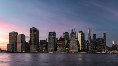 New York 'taki Brooklyn Köprüsü Parkı' ndan görülen alacakaranlık sırasında aşağı Manhattan 'ın silüeti