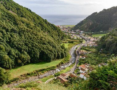 Azores takımadasındaki Sao Miguel adasının güney kıyısı boyunca uzanan küçük Faial da Terra kasabasının panoramik manzarası.