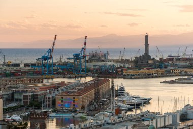 Panoramic view of the harbor of Genoa with Lanterna lighthouse in the background during the sunset. Liguria, Italy