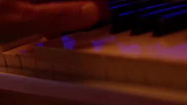 Playing on piano keyboard close up video recording indoor low light environment