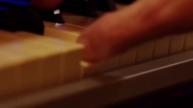 Playing on piano keyboard close up video recording indoor low light environment