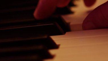 Playing on piano keyboard close up video recording indoor low light environment