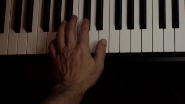 Playing on piano keyboard close up video recording indoor low light environment