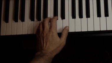 Playing on piano keyboard close up video recording indoor low light environment