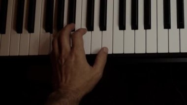 Playing on piano keyboard close up video recording indoor low light environment