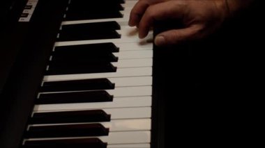 Playing on piano keyboard close up video recording indoor low light environment