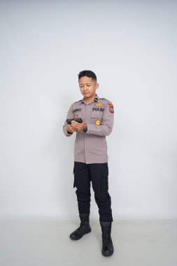 Genç Endonezyalı bir polis memuru reklam için fotoğraf çekiyor.