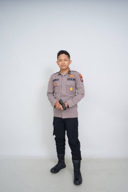Genç Endonezyalı bir polis memuru reklam için fotoğraf çekiyor.