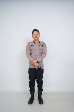 Genç Endonezyalı bir polis memuru reklam için fotoğraf çekiyor.