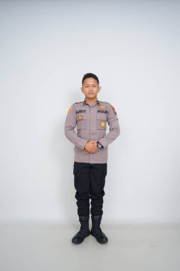 Genç Endonezyalı bir polis memuru reklam için fotoğraf çekiyor.