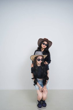 Güneş gözlüklü ve şapkalı güzel bir kız yerde oturuyor. yüksek kaliteli fotoğraf