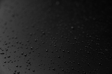 Yerde siyah arka planlı su damlacıkları var.