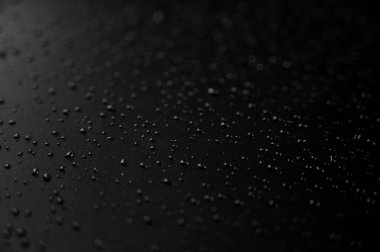 Yerde siyah arka planlı su damlacıkları var.