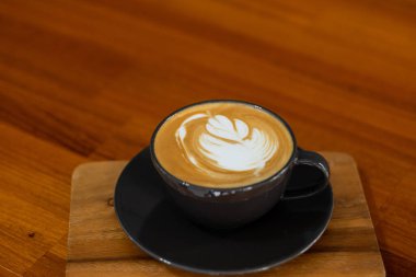 Tahta masada sıcak latte sanat kahvesi, rahatla Tim.