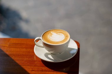 Tahta masada sıcak latte sanat kahvesi, rahatla Tim.