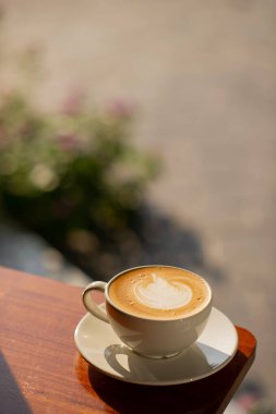 Tahta masada sıcak latte sanat kahvesi, rahatla Tim.