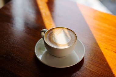 Tahta masada sıcak latte sanat kahvesi, rahatla Tim.