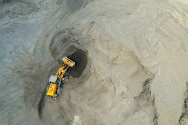 Kum yükleyicileri çöp kamyonlarına taş topluyor.