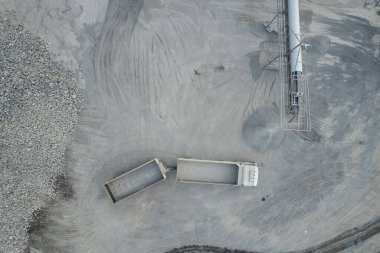 Kum yükleyicileri çöp kamyonlarına taş topluyor.