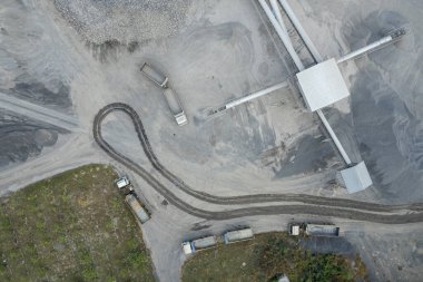 Kum yükleyicileri çöp kamyonlarına taş topluyor.