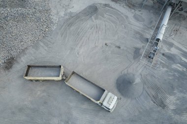 Kum yükleyicileri çöp kamyonlarına taş topluyor.