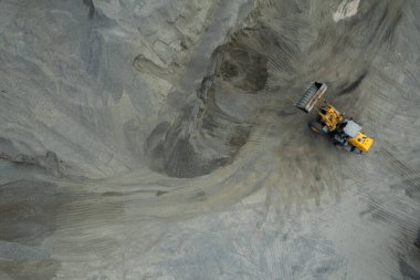 Kum yükleyicileri çöp kamyonlarına taş topluyor.