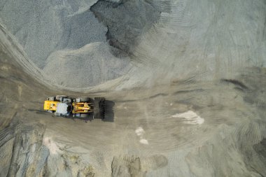 Kum yükleyicileri çöp kamyonlarına taş topluyor.