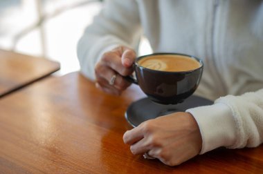 Tahta masada sıcak latte sanat kahvesi, rahatla Tim.