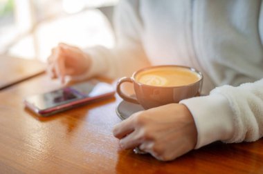 Tahta masada sıcak latte sanat kahvesi, rahatla Tim.