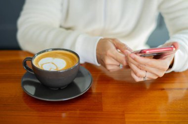 Tahta masada sıcak latte sanat kahvesi, rahatla Tim.