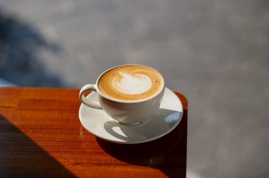 Tahta masada sıcak latte sanat kahvesi, rahatla Tim.