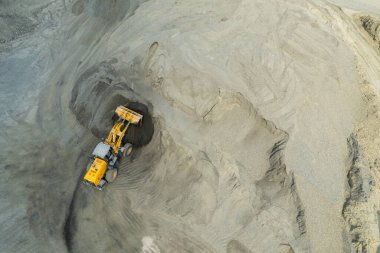 Kum yükleyicileri çöp kamyonlarına taş topluyor.