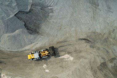 Kum yükleyicileri çöp kamyonlarına taş topluyor.