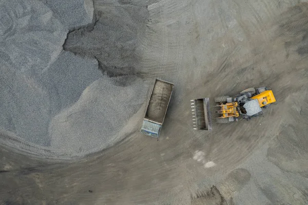 装砂机正在把石头铲到垃圾车里 — 图库照片