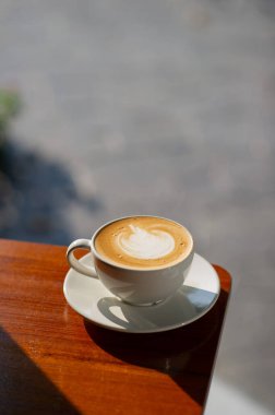 Tahta masada sıcak latte sanat kahvesi, rahatla Tim.