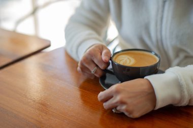 Tahta masada sıcak latte sanat kahvesi, rahatla Tim.