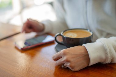 Tahta masada sıcak latte sanat kahvesi, rahatla Tim.