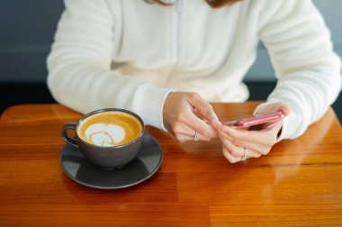 Tahta masada sıcak latte sanat kahvesi, rahatla Tim.