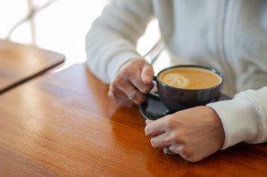 Tahta masada sıcak latte sanat kahvesi, rahatla Tim.