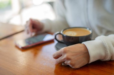 Tahta masada sıcak latte sanat kahvesi, rahatla Tim.